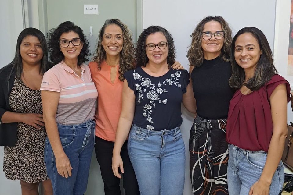 Foto com seis mulheres em pé, sorrindo para a foto, membras da equipe da coordenação.